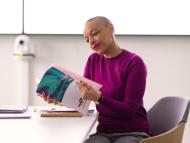 Collaboratrice seule dans une salle de réunion devant son laptop avec feuilles de notes et gourde