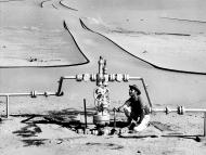 Compagnie de recherche et d'exploitation de pétrole au Sahara (CREPS) - Centrale de détente dans le Sahara - Relevé de pression effectué par un homme accroupi. Elf aquitaine